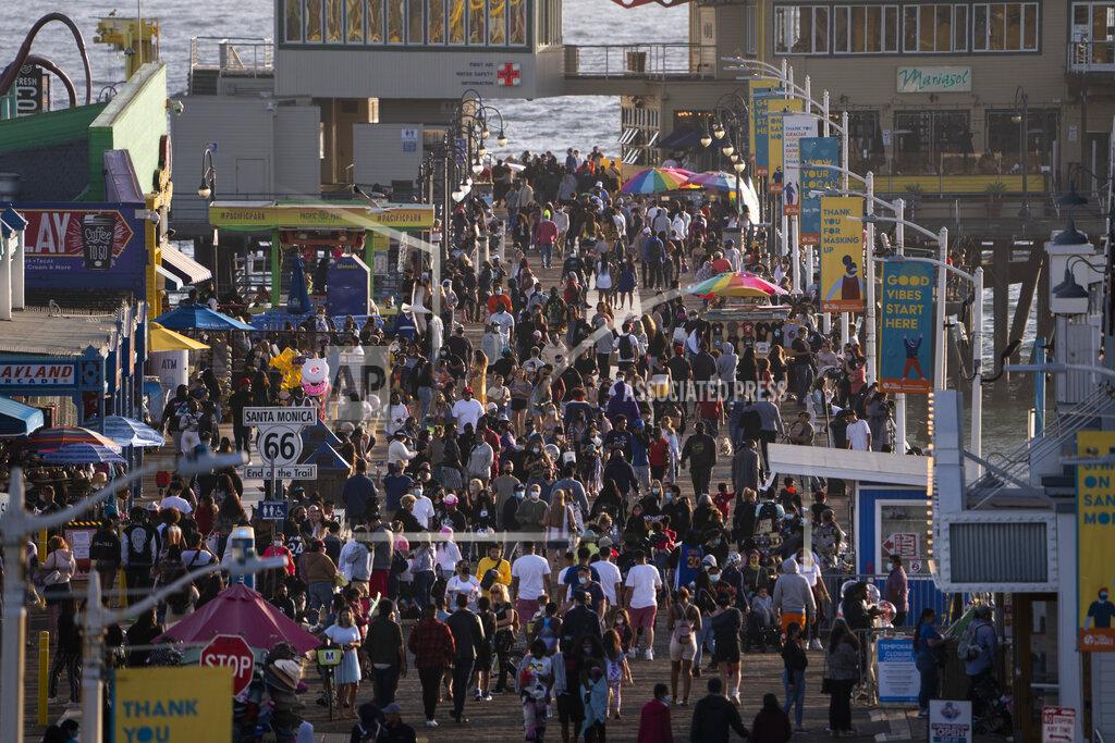 Jae C. Hong FILE - In this April 7, 2021, file photo, people gather on the Santa Monica Pier in Santa Monica, Calif. Los Angeles County is expected to move Tuesday, May 4 into the least-restrictive yellow tier this week, amid the coronavirus pandemic. (AP Photo/Jae C. Hong)