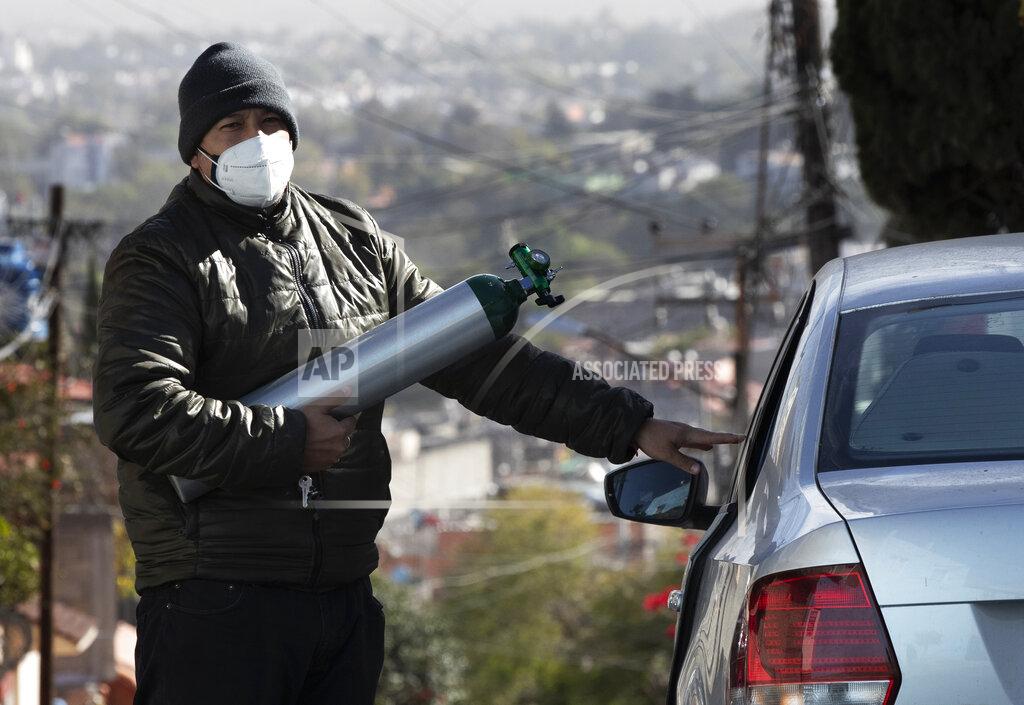 Marco Ugarte Ricardo Ledesma Carrasco gets into his car after refilling a tank of oxygen at a store for his dad who is being treated for COVID-19 at home in Mexico City, Thursday, Dec. 31, 2020. Carrasco's mother also has COVID-19. (AP Photo/Marco Ugarte)