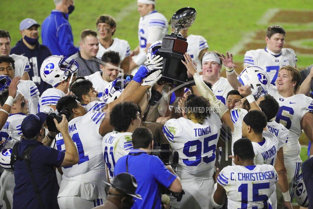 Al Diaz BYU players hold the championship trophy after defeating UCF in the Boca Raton Bowl NCAA college football game at FAU Stadium in Boca Raton, Fla. Tuesday, Dec. 22, 2020.(Al Diaz/Miami Herald via AP)