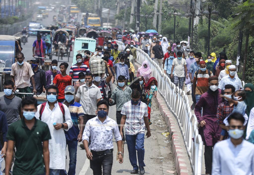 Mahmud Hossain Opu People wearing face masks a precaution against the coronavirus leave the city to travel to their native places ahead of Eid al-Fitr in Dhaka, Bangladesh, Friday, May 7, 2021. India's surge in coronavirus cases is having a dangerous effect on neighboring Bangladesh. Health experts warn of imminent vaccine shortages just as the country should be stepping up its vaccination drive, and as more contagious virus variants are beginning to be detected. (AP Photo/Mahmud Hossain Opu)