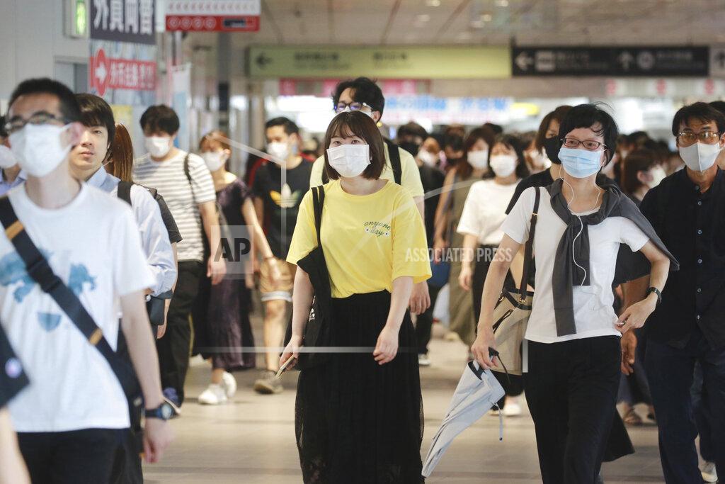 Koji Sasahara People wearing face masks to protect against the spread of the coronavirus walk at a train station in Tokyo, Wednesday, July 28, 2021. Tokyo Gov. Yuriko Koike on Wednesday urged younger people to cooperate with measures to bring down the high number of infections and get vaccinated, saying their activities are key to slowing the surge during the Olympics. On Tuesday, the Japanese capital reported 2,848 new cases, exceeding its previous record in January. (AP Photo/Koji Sasahara)