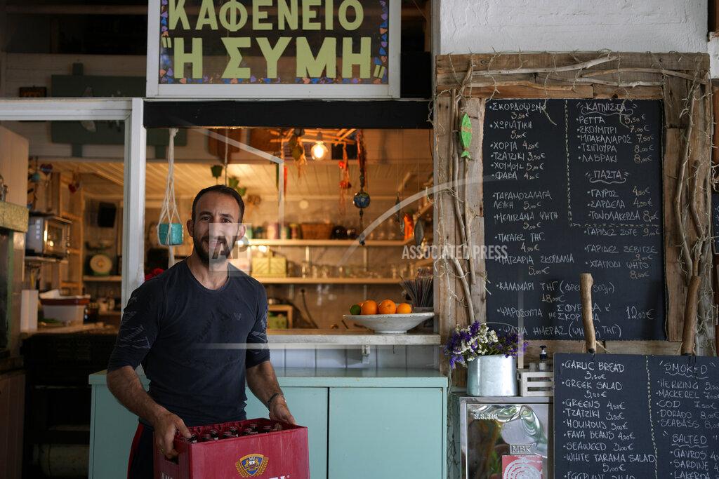 Thanassis Stavrakis Fish restaurant owner Paris Parasos, 34, poses in the main town of the Aegean Sea island of Rhodes, southeastern Greece, Tuesday, May 10, 2022. Russia's war in Ukraine has accelerated inflation across Europe, with prices for energy, materials and food surging at rates not seen for decades. Inflation is expected to hit nearly 7% this year in the 27-nation EU and is contributing to slowing growth forecasts. (AP Photo/Thanassis Stavrakis)