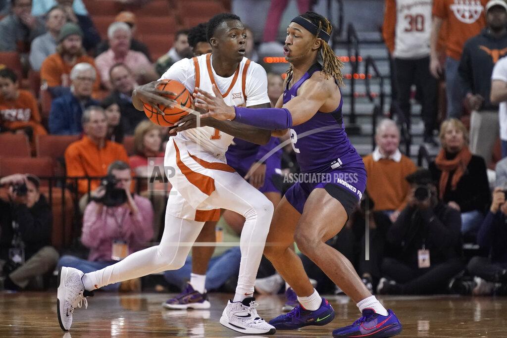 Chuck Burton Texas guard Andrew Jones (1) is guarded by TCU forward Xavier Cork (12) during the first half of an NCAA college basketball game in Austin, Texas, Wednesday, Feb. 23, 2022. (AP Photo/Chuck Burton)