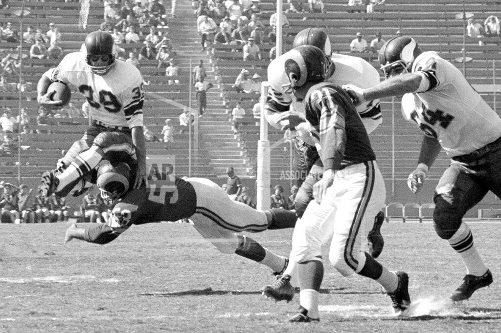 Harold Filan FILE - Minnesota Vikings halfback Hugh McElhenny, left, takes to the air to get past a Los Angeles Rams tackler during an NFL football game in Los Angeles, on Oct. 21, 1962. McElhenny, an elusive NFL running back nicknamed “The King,” died on June 17, 2022, at his home in Nevada, his son-in-law Chris Permann confirmed Thursday, June 23, 2022. He was 93. (AP Photo/Harold Filan, File)