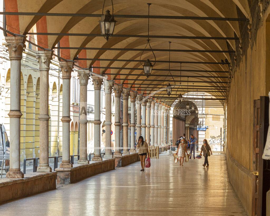 Guido Calamosca People walk along the porticoes in Bologna, Italy, Wednesday, July 28, 2021. Bologna's 12th-century porticoes, still part of the city's everyday life, have been added to the World Heritage List. At a meeting in China on Wednesday, the World Heritage Committee of UNESCO, the U.N. culture agency, inscribed the porticoes on the prestigious list. The addition raises to 58 the number of Italian sites on the list. (Guido Calamosca/LaPresse via AP)