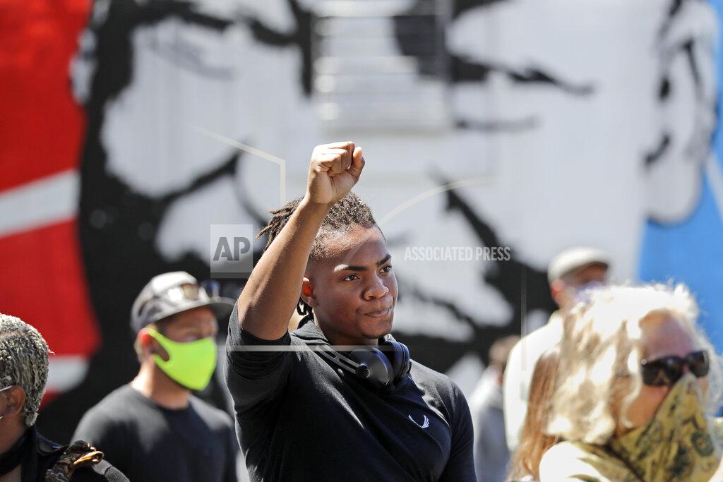 Elaine Thompson FILE - In this Monday, June 1, 2020 file photo, Hanz Jouissance holds up a fist at the conclusion of a prayer vigil at the First AME church in Seattle, following protests over the weekend over the death of George Floyd, a Black man who was in police custody in Minneapolis. (AP Photo/Elaine Thompson)