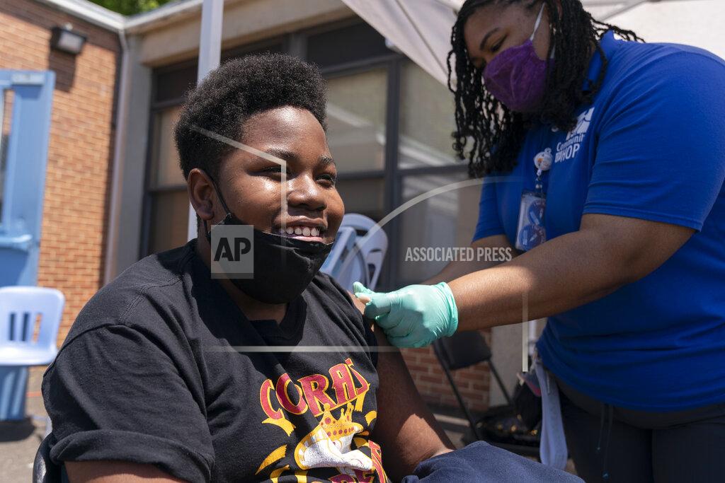 Jacquelyn Martin Christopher Fitzhugh, 13, of Washington, laughs in relief that his shot didn't hurt, as Leah Napier, a certified clinical medical assistant, completes his Pfizer COVID-19 vaccine, Wednesday, May 19, 2021, at a clinic held by Community of Hope, a community health organization, at the Washington School for Girls in southeast Washington. Several schools sent information about the vaccine drive to their students' families to ensure access to the vaccine, newly approved for children ages 12-15. "I wanted to get it out of the way," says Fitzhugh, "I'm not trying to get COVID and I'm trying to get vaccinated so I can see my friends." (AP Photo/Jacquelyn Martin)