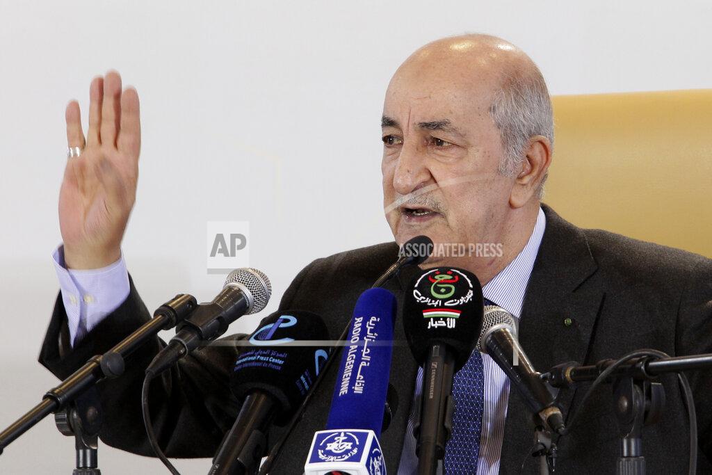 Fateh Guidoum FILE - In this Friday, Dec. 13, 2019 file photo, newly elected Algerian President Abdelmadjid Tebboune gestures during a press conference in Algiers. Tebboune has been transferred to Germany for specialist medical treatment a day after his country’s presidency announced he had been hospitalized but not revealed why. Several senior officials in the 75-year-old president’s entourage developed COVID-19 symptoms on Saturday, Oct. 24, 2020 and the president was placed in what the government called “voluntary preventive confinement.”(AP Photo/Fateh Guidoum, file)