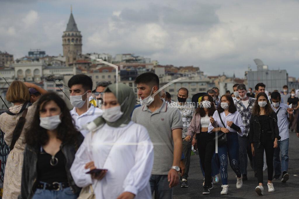 Yasin Akgul Backdropped by Istanbul's iconic Galata Tower, people wearing masks for protection against the spread of coronavirus, walk over Eminonu bridge in Istanbul, Friday, Sept. 11, 2020. Turkey is getting tough on people who flout self-isolation rules despite testing positive for the coronavirus. An Interior Ministry circular sent to the country's 81 provinces on Friday said people caught leaving their homes despite isolation orders will be quarantined and supervised at state-owned dormitories or hostels. (AP Photo/Yasin Akgul)