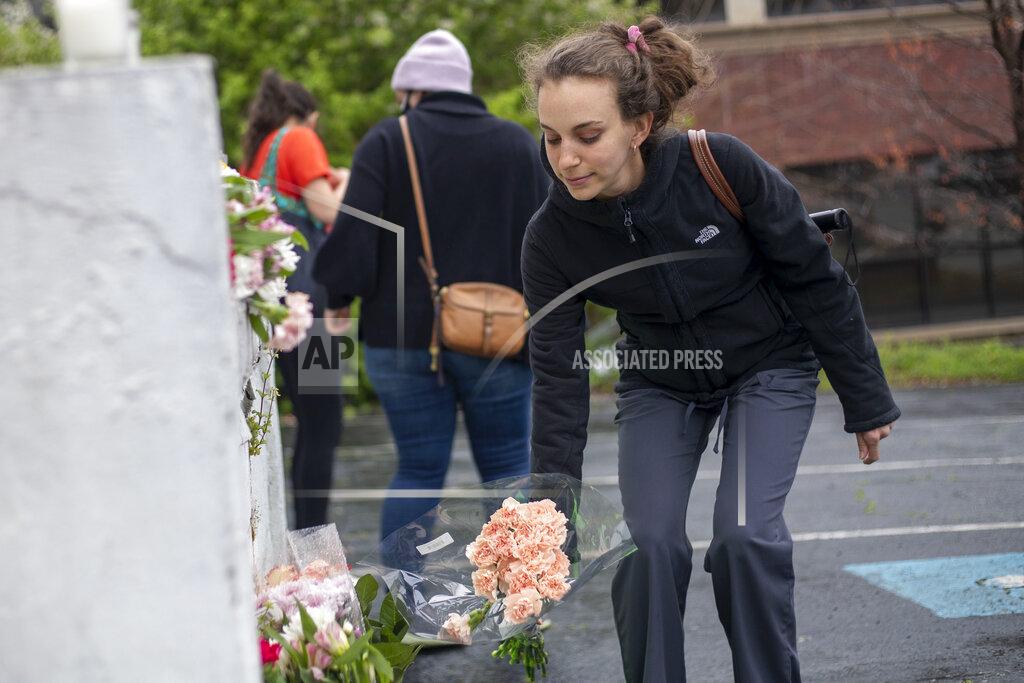 Alyssa Pointer A woman places flowers near a makeshift memorial outside of the Gold Spa in Atlanta, Wednesday, March 17, 2021. Police in the Atlanta suburb of Gwinnett County say they've begun extra patrols in and around Asian businesses there following the shooting at three massage parlors in the area that killed eight, most of them women of Asian descent. (Alyssa Pointer/Atlanta Journal-Constitution via AP)