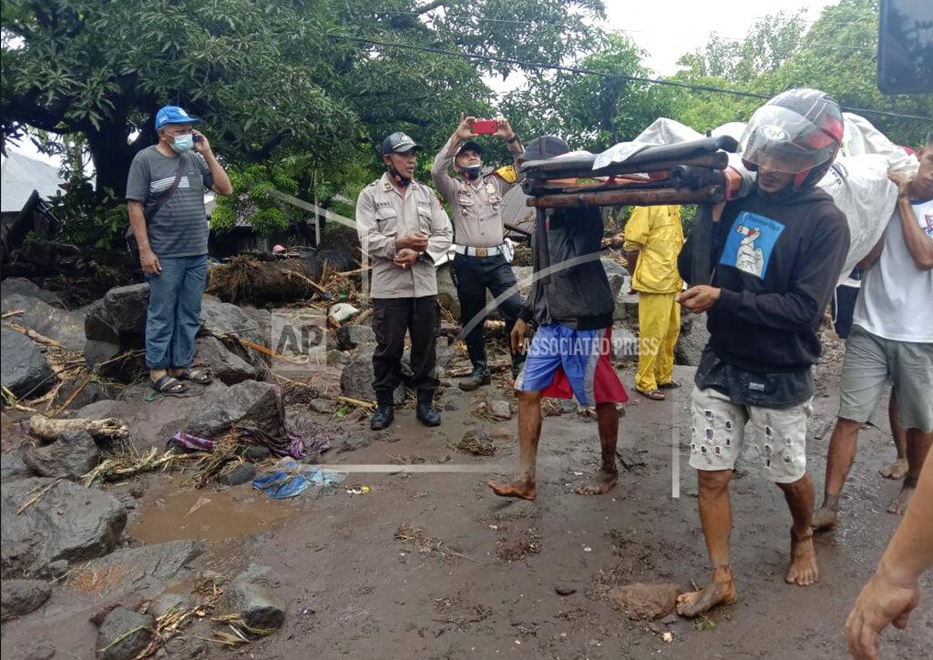 Ricko Wawo People carry a man injured during a flood in Ile Ape, on Lembata Island, East Nusa Tenggara province, Indonesia, Sunday, April 4, 2021. Multiple disasters caused by torrential rains in eastern Indonesia have left dozens of people dead or missing while displacing thousands, the country's disaster relief agency said Monday. (AP Photo/Ricko Wawo)