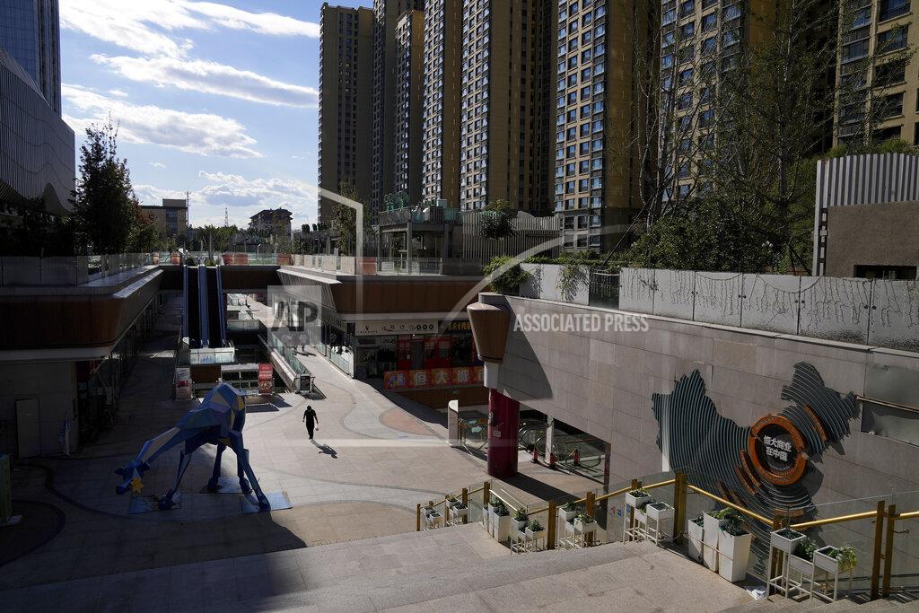 Andy Wong A man walks through a quiet Evergrande city plaza past a map showing Evergrande development projects and its apartment buildings in Beijing, Tuesday, Sept. 21, 2021. Global investors are watching nervously as the Evergrande Group, one of China's biggest real estate developers, struggles to avoid defaulting on tens of billions of dollars of debt, fueling fears of possible wider shock waves for the Chinese financial system. (AP Photo/Andy Wong)
