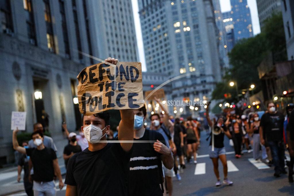 John Minchillo FILE - In this Thursday, July 30, 2020, file photo, a demonstrator holds a sign that reads "Defund the Police," during a protest march in support of the Black Lives Matter movement and other groups, in New York. The racial justice protests following the death of George Floyd spurred calls to “defund the police” in cities across the country, a priority for activists that has now become a central point in the presidential contest. (AP Photo/John Minchillo, File)