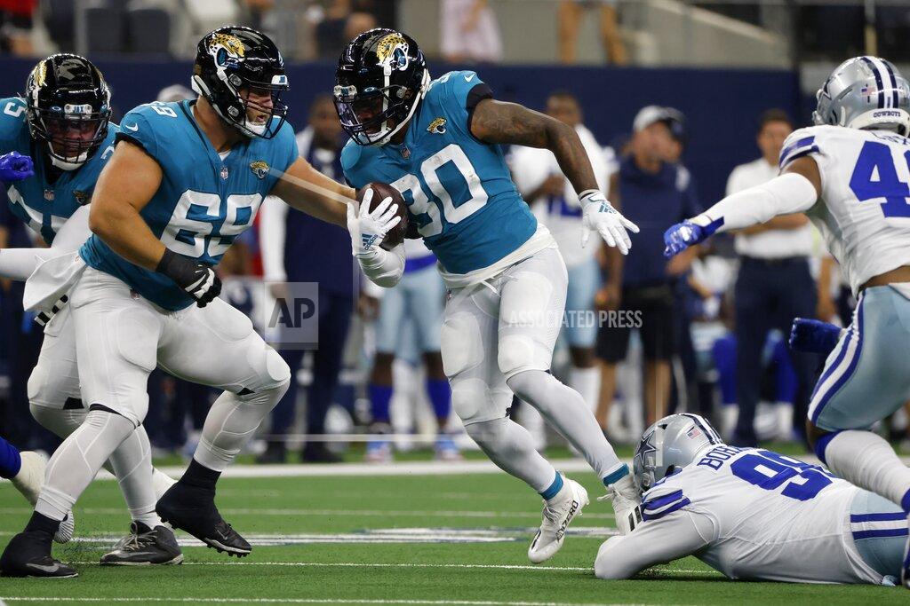 Michael Ainsworth Jacksonville Jaguars running back James Robinson (30) evades tackle attempt by the Dallas Cowboys as he carries the ball for a gain in the first half of a preseason NFL football game in Arlington, Texas, Sunday, Aug. 29, 2021. (AP Photo/Michael Ainsworth)