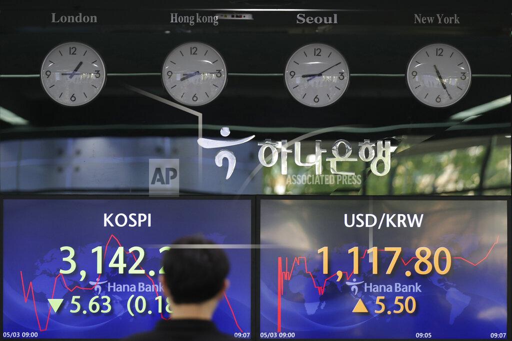 Lee Jin-Man A currency trader walks near screens showing the Korea Composite Stock Price Index (KOSPI), left, and the foreign exchange rate between U.S. dollar and South Korean won at a bank's foreign exchange dealing room in Seoul, South Korea, Monday, May 3, 2021. Shares were mostly lower in Asia in thin trading Monday, with many markets including those in Tokyo and Shanghai closed for holidays. (AP Photo/Lee Jin-man)