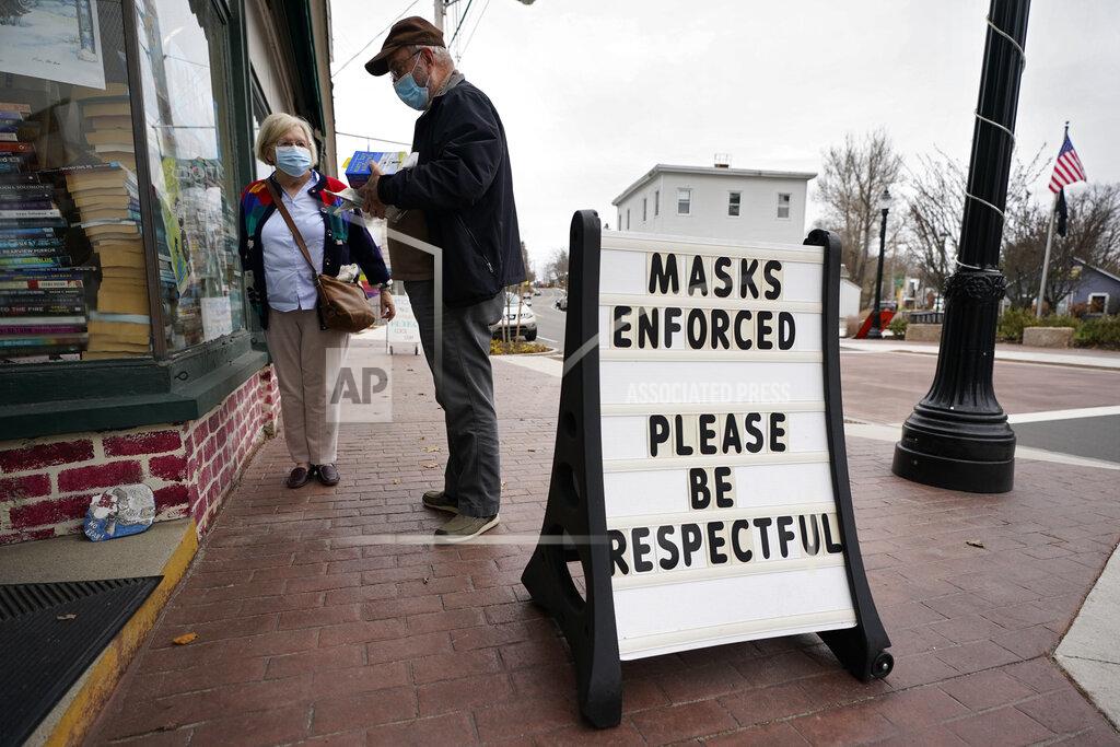 Robert F. Bukaty Shoppers comply with the mask regulations to help prevent the spread of the coronavirus at Bridgton Books, Friday, Nov. 13, 2020, in Bridgton, Maine. With the coronavirus coming back with a vengeance across the country and the U.S. facing a long, dark winter, governors and other elected officials are showing little appetite for reimposing the kind of lockdowns and large-scale business closings seen last spring. (AP Photo/Robert F. Bukaty)
