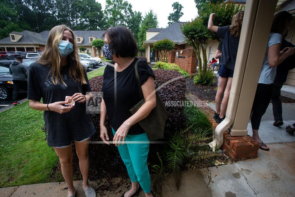 Ron Harris Middle school student Meredith Rogers, left, waits outside the DeKalb Pediatric Center after receiving her first coronavirus vaccination on Wednesday, May 12, 2021, in Decatur, Ga. Hundreds of children, ages 12 to 15, received the Pfizer vaccine at the center, just days after it was approved for use within their age group. (AP Photo/Ron Harris)