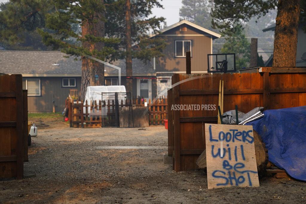 Jae C. Hong A warning sign is placed outside an evacuated home as fire crews continue to battle the Caldor Fire in Meyers, Calif., Friday, Sept. 3, 2021. Fire crews took advantage of decreasing winds to battle a California wildfire near popular Lake Tahoe and were even able to allow some people back to their homes but dry weather and a weekend warming trend meant the battle was far from over. (AP Photo/Jae C. Hong)