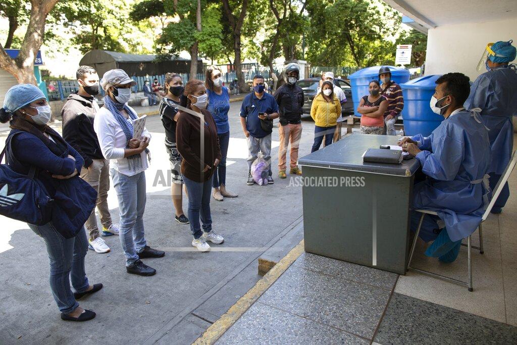 Ariana Cubillos Dr. Wilfredo Sifontes, right, speaks to families who have family hospitalized in the COVID-19 wing, outside José Gregorio Hernández Hospital in the Catia neighborhood of Caracas, Venezuela, Friday, Sept 4, 2020. Sifontes, who oversees the hospital’s emergency services including its coronavirus wing, described having a fever, cough and feeling sick. Though he oversees testing kits, he himself was never tested and continued to clock in. He dismissed the threat of the coronavirus, comparing it to a “common flu” that’s sparked needless panic. (AP Photo/Ariana Cubillos)