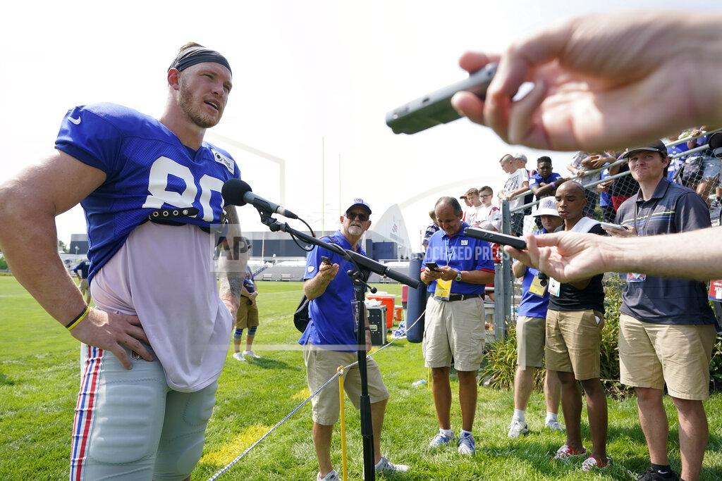 Steven Senne New York Giants tight end Kyle Rudolph, left, faces reporters following a joint NFL football practice with the New England Patriots, Wednesday, Aug. 25, 2021, in Foxborough, Mass. (AP Photo/Steven Senne)