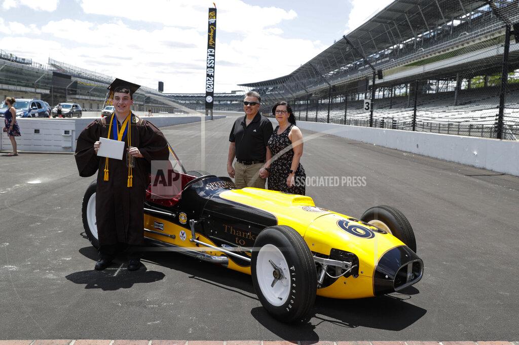 Michael Conroy Jacob Foxworthy, left, poses with his parents Ted and Cindy Foxworthy around a vintage race car after he received his Speedway High School diploma during a ceremony at the Indianapolis Motor Speedway in Indianapolis, Saturday, May 30, 2020. When Ted Foxworthy was diagnosed with cancer, he set two goals: Celebrating his youngest child's 18th birthday and seeing him graduate. (AP Photo/Michael Conroy)