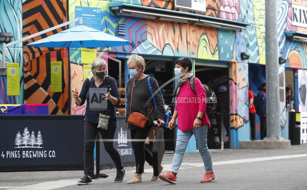 Hamish Blair Spectators wearing masks walk outside a court ahead of the first round matches at the Australian Open tennis championship in Melbourne, Australia, Monday, Feb. 8, 2021.(AP Photo/Hamish Blair)