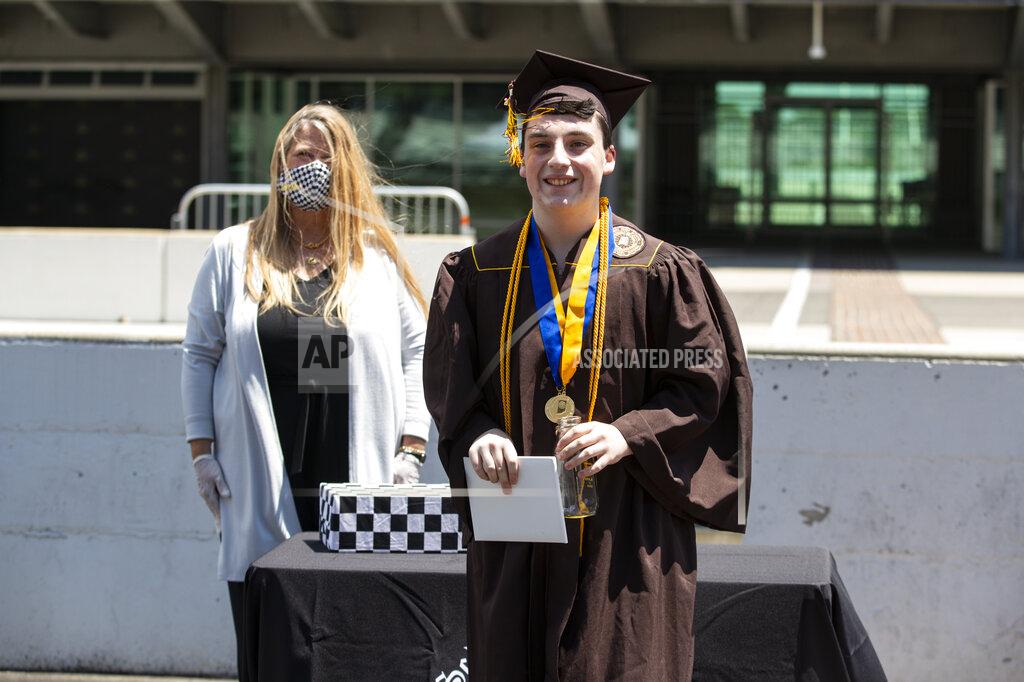 Michael Conroy Jacob Foxworthy receives his Speedway High School diploma during a ceremony at the Indianapolis Motor Speedway in Indianapolis, Saturday, May 30, 2020. The ceremony was held at the track to allow for social distancing requirements due to the COVID-19 pandemic. When Ted Foxworthy was diagnosed with cancer, he set two goals: Celebrating his youngest child's 18th birthday and seeing him graduate. (AP Photo/Michael Conroy)