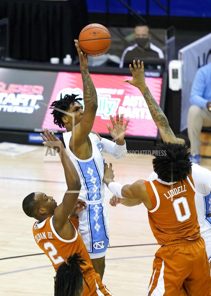 Kathy Kmonicek North Carolina guard Caleb Love (2) shoots next to Texas guard Matt Coleman III (2) and forward Gerald Liddell (0) during the second half of an NCAA college basketball game for the championship of the Maui Invitational, Wednesday, Dec. 2, 2020, in Asheville, N.C. (AP Photo/Kathy Kmonicek)