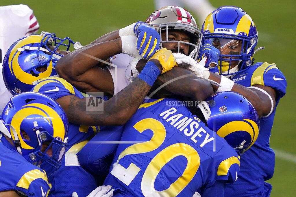 Tony Avelar San Francisco 49ers running back Raheem Mostert, center, is tackled by Los Angeles Rams defenders during the first half of an NFL football game in Santa Clara, Calif., Sunday, Oct. 18, 2020. (AP Photo/Tony Avelar)