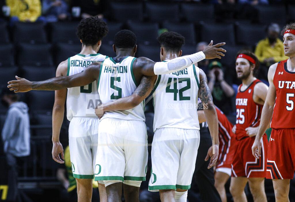 Thomas Boyd Oregon guard De'Vion Harmon (5) celebrates with Will Richardson (0) and Jacob Young (42) during the second half of the team's NCAA college basketball game against Utah in Eugene, Ore., Saturday, Jan. 1, 2022. (AP Photo/Thomas Boyd)
