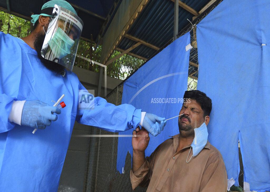 Fareed Khan A man reacts while having a nasal swab sample taken at a testing and screening facility for the coronavirus, in a hospital in Karachi, Pakistan, Friday, Aug. 21, 2020. (AP Photo/Fareed Khan)