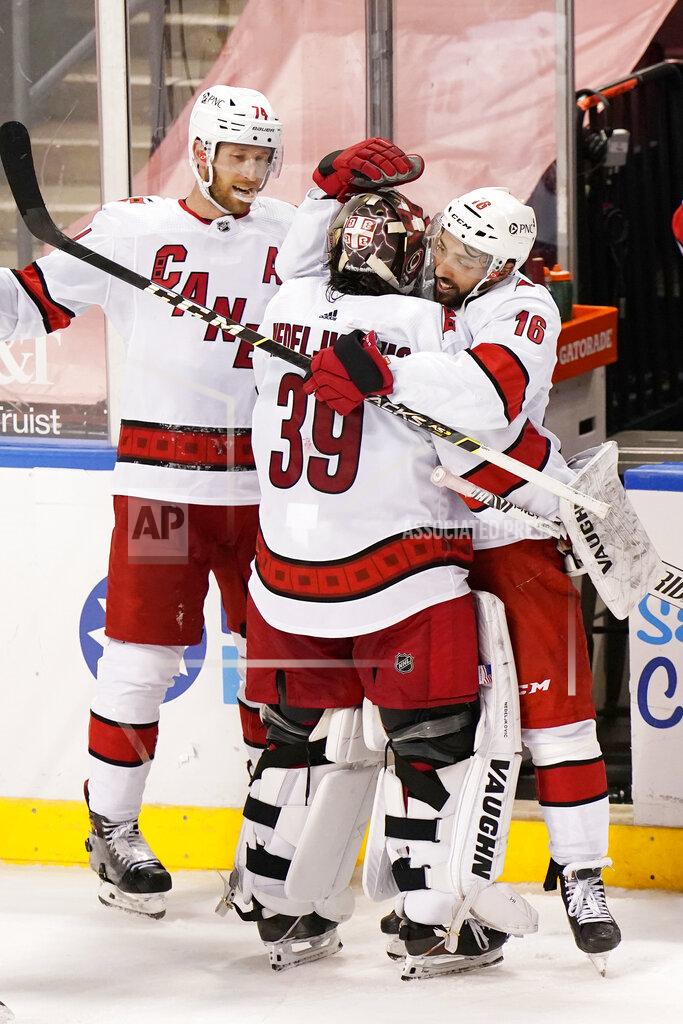 Wilfredo Lee Carolina Hurricanes center Vincent Trocheck (16) and defenseman Jaccob Slavin (74) celebrate with goaltender Alex Nedeljkovic (39) after the Hurricanes defeated the Florida Panthers 3-2 in an overtime period of an NHL hockey game, Monday, March 1, 2021, in Sunrise, Fla. (AP Photo/Wilfredo Lee)