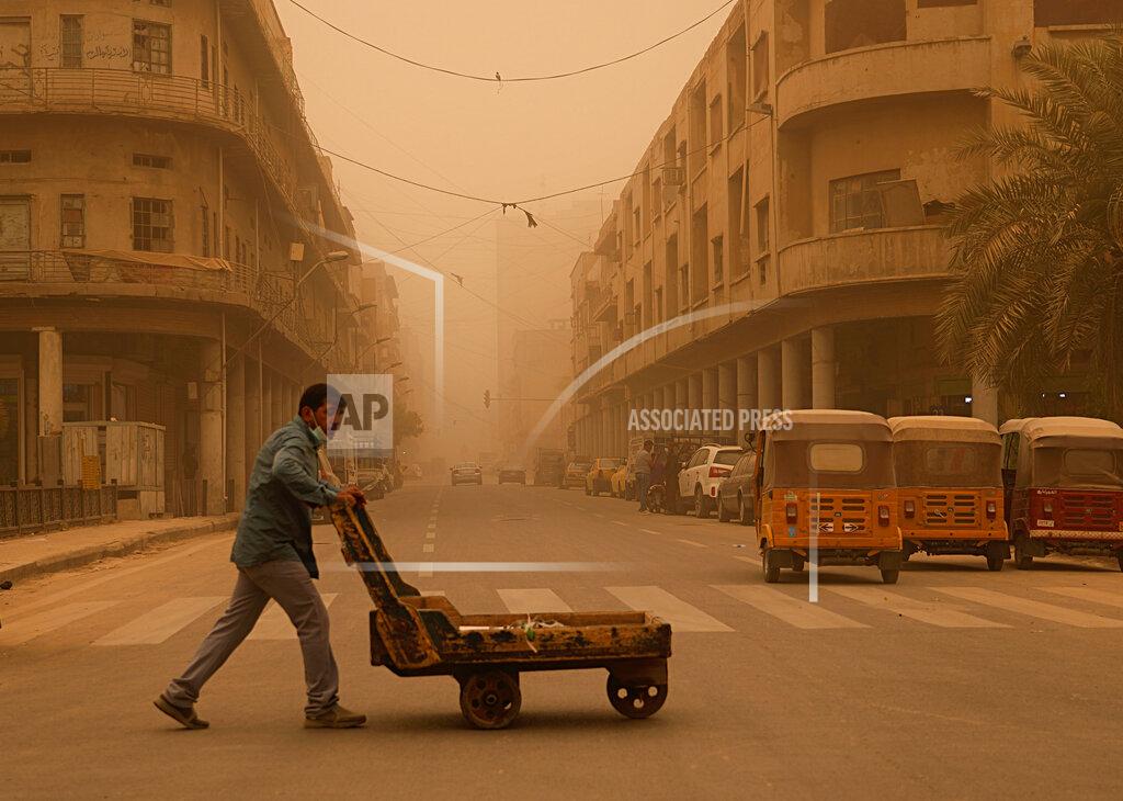 Hadi Mizban A man pushes a cart during a sandstorm in Baghdad, Iraq, Monday, May 23, 2022. (AP Photo/Hadi Mizban)