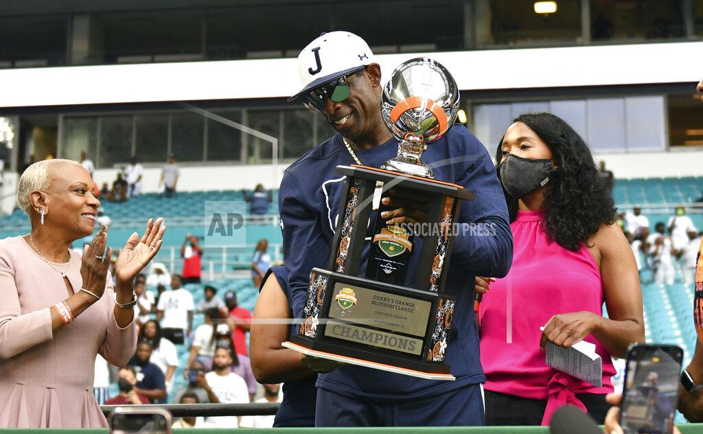 Jim Rassol Jackson State head football coach Deion Sanders, center, holds the Orange Blossom Classic trophy after winning an NCAA college football game over Florida A&M, Sunday, Sept. 5, 2021, in Miami Gardens, Fla. (AP Photo/Jim Rassol)