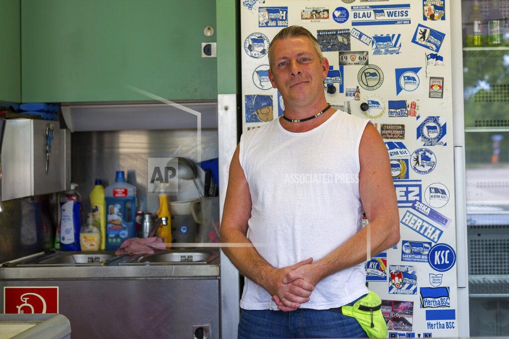 Ciaran Fahey Fast food vendor Sven Grosch poses for a picture before the German soccer cup (DFB Pokal) final match between Bayer 04 Leverkusen and FC Bayern Munich in Berlin, Germany, Saturday, July 4, 2020. Normally the roads around Olympiastadion would be teeming with traffic, fans, noise and color, but they were eerily quiet before kickoff. Grosch’s was the only one open in front of Berlin’s iconic stadium. (AP Photo/Ciaran Fahey)