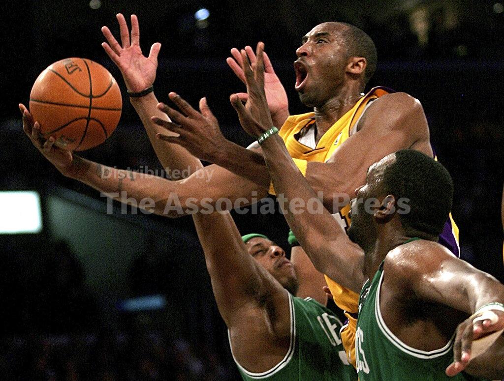 FILE - In this Feb. 23, 2006, file photo, Los Angeles Lakers' Kobe Bryant, top, goes up for a shot between the Boston Celtics' Paul Pierce, left, and Al Jefferson during the first half of an NBA basketball game in Los Angeles. Bryant, the 18-time NBA All-Star who won five championships and became one of the greatest basketball players of his generation during a 20-year career with the Los Angeles Lakers, died in a helicopter crash Sunday, Jan. 26, 2020. (AP Photo/Branimir Kvartuc, File)