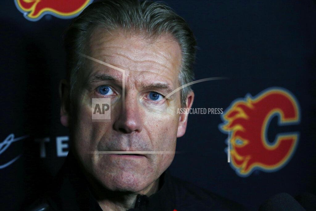 Jeffrey T. Barnes Calgary Flames associate coach Geoff Ward addresses the media following a NHL hockey practice Tuesday, Nov. 26, 2019, in Buffalo, N.Y. Flames general manager Brad Treliving says coach Bill Peters remains on the staff but wasn’t certain whether he’d be behind the bench for the next game. The team and the NHL are both investigating an allegation the Peters directed racial slurs at a player 10 years ago when the two were in the minors. Akim Aliu, a Nigerian-born player, says Peters “dropped the N bomb several times” in a dressing room during his rookie year.(AP Photo/Jeffrey T. Barnes)