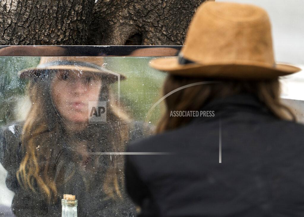 Dawn Woodward Dawn Woodward, 39, who is homeless and originally from Arizona, checks herself in the mirror set outdoors in a homeless camp on the side of the CA-101 highway in the Echo Park neighborhood in Los Angeles Tuesday, May 11, 2021. California Gov. Gavin Newsom on Tuesday proposed $12 billion in new funding to get more people experiencing homelessness in the state into housing and to “functionally end family homelessness” within five years. (AP Photo/Damian Dovarganes)