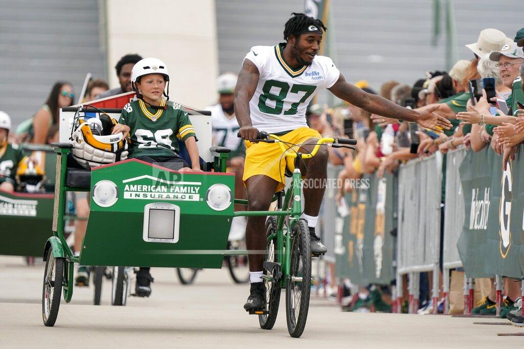 Morry Gash Green Bay Packers' Romeo Doubs rides a bike to the NFL football team's practice field Wednesday, July 27, 2022, in Green Bay, Wis. (AP Photo/Morry Gash)