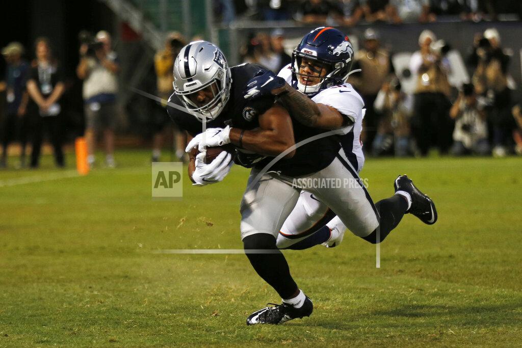 D. Ross Cameron Oakland Raiders wide receiver Tyrell Williams scores a touchdown as Denver Broncos free safety Justin Simmons looks on during the first half of an NFL football game Monday, Sept. 9, 2019, in Oakland, Calif. (AP Photo/D. Ross Cameron)