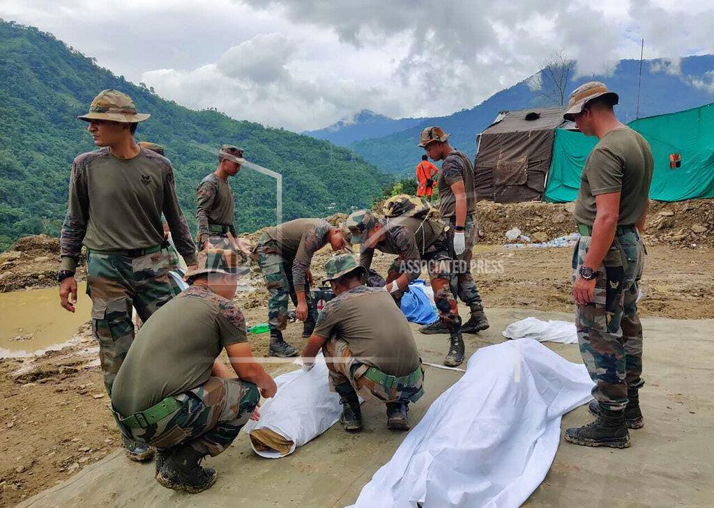 Agui Kamei Soldiers wrap bodies of victims of a mudslide in Noney, northeastern Manipur state, India, Friday, July 1, 2022. Rescuers found more bodies Friday as they resumed searching for dozens of missing after a mudslide triggered by weeks of heavy downpours killed at least 19 people at a railroad construction site in India's northeast, officials said. (AP Photo/Agui Kamei)
