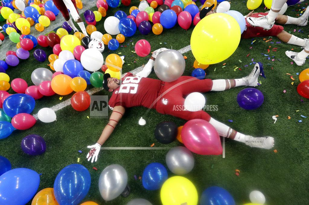 Eric Gay Washington State defensive lineman Dallas Hobbs rolls between balloons as he he celebrates the team's 28-26 win over Iowa State in the Alamo Bowl NCAA college football game Friday, Dec. 28, 2018, in San Antonio. (AP Photo/Eric Gay)