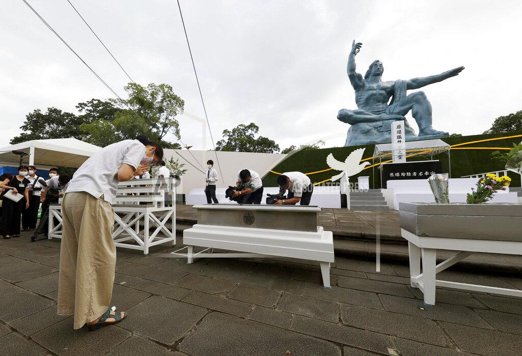 085123+0900 A woman prays for the victims of U.S. atomic bombing in front of the Statue of Peace at the Peace Park in Nagasaki, southern Japan Sunday, Aug. 9, 2020. Nagasaki marked the 75th anniversary of the atomic bombing on Sunday. (Kyodo News via AP)