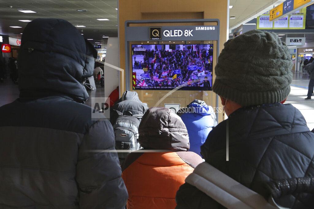 Ahn Young-Joon People watch a TV screen showing the news on a violent mob that loyal to U.S. President Donald Trump stormed the U.S. Capitol, at the Seoul Railway Station in Seoul, South Korea, Thursday, Jan. 7, 2021. (AP Photo/Ahn Young-joon)
