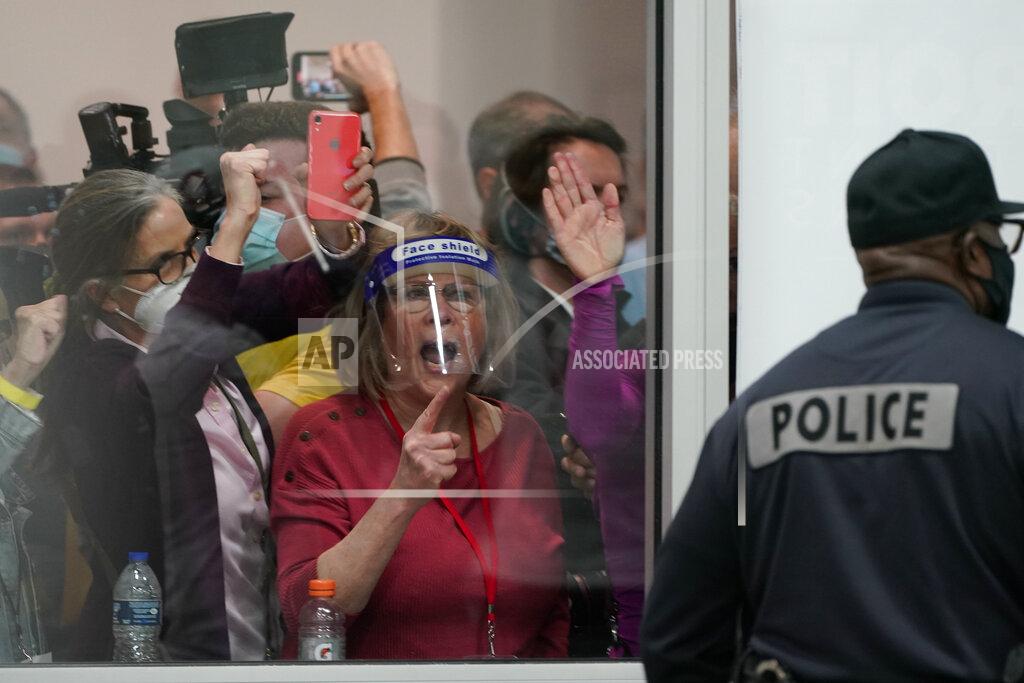 Carlos Osorio People yell as they look through the windows of the central counting board as police were helping to keep others from entering due to overcrowding, Wednesday, Nov. 4, 2020, in Detroit. (AP Photo/Carlos Osorio)
