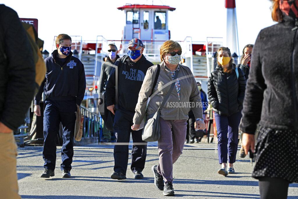 Robert F. Bukaty Commuters from Peaks Island arrive on the mainland, Thursday, May 21, 2020, in Portland, Maine. Ferry passengers are required to wear masks during the coronavirus pandemic. (AP Photo/Robert F. Bukaty)