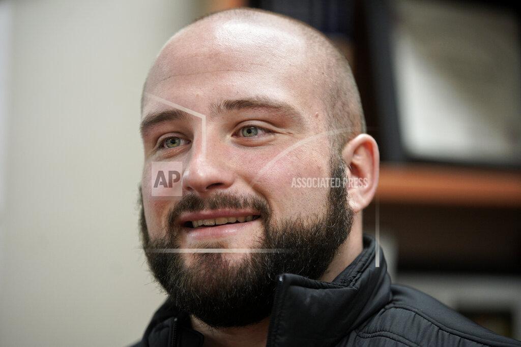 Nati Harnik In this March 2, 2020, photo, former Nebraska football player Tanner Farmer and current wrestler for Concordia University smiles during an interview with the Associated Press, in Seward, Neb. A year ago Farmer was thought to be on the rise as an NFL draft prospect. He had started three years on Nebraska's offensive line and turned in a stellar performance at the Cornhuskers' pro day. It turned out he went undrafted, so he took a volunteer assistant's job with the Concordia football team and then, quite by accident, discovered he had one semester of eligibility to compete in another sport in the National Association of Intercollegiate Athletics. He chose wrestling. (AP Photo/Nati Harnik)