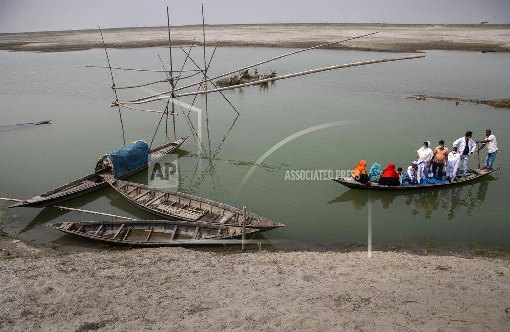 Anupam Nath Health workers accompany elderly villagers in a boat as they cross the river Brahmaputra to reach a vaccination center for COVID-19 at Bahakajari village in an interior part of Indian northeastern state of Assam, India, Tuesday, March 23, 2021. (AP Photo/Anupam Nath)
