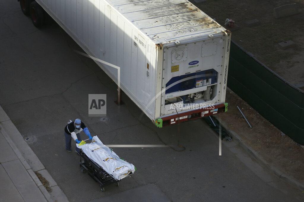 Briana Sanchez Medical workers use the mobile morgues near the El Paso Medical Examiner Monday, Nov. 9, 2020, as coronavirus cases spike in El Paso, Texas. County Judge Ricardo Samaniego said the county has requested four more trailers in addition to the six mobile morgues. (Briana Sanchez/The El Paso Times via AP)