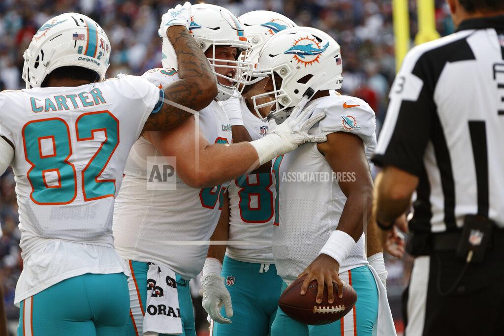 Winslow Townson Miami Dolphins quarterback Tua Tagovailoa, right, is congratulated by teammates after his touchdown during the first half of an NFL football game against the New England Patriots, Sunday, Sept. 12, 2021, in Foxborough, Mass. (AP Photo/Winslow Townson)